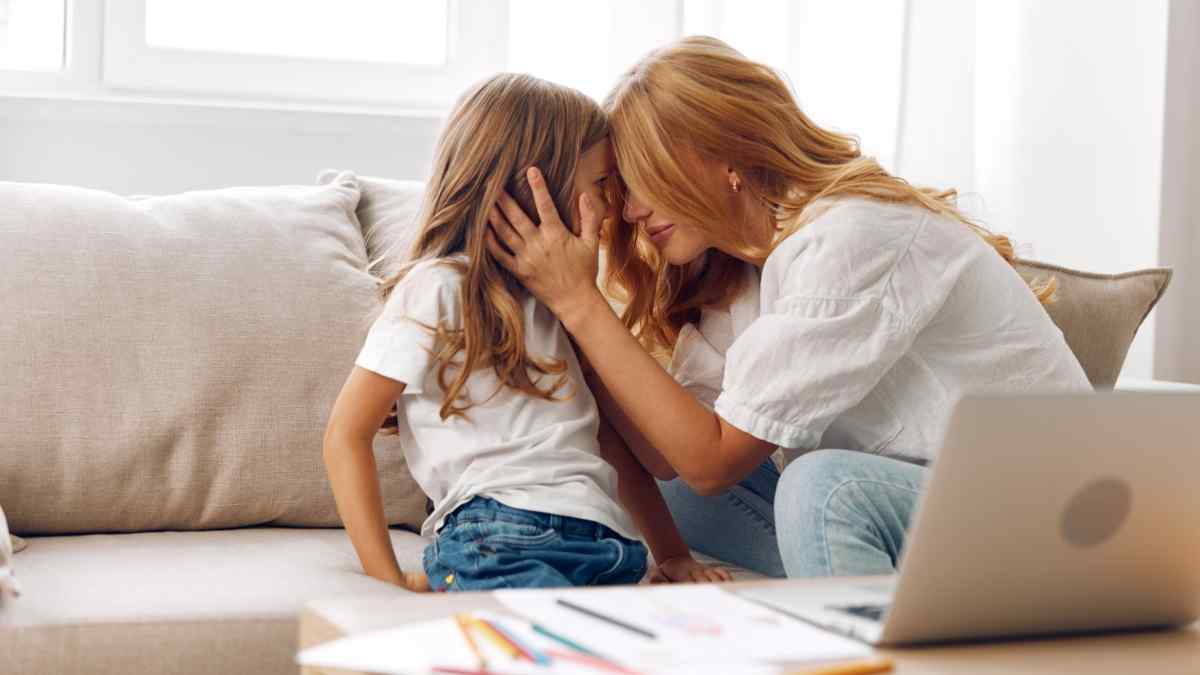 Parent holding her daughter's face, foreheads touching.